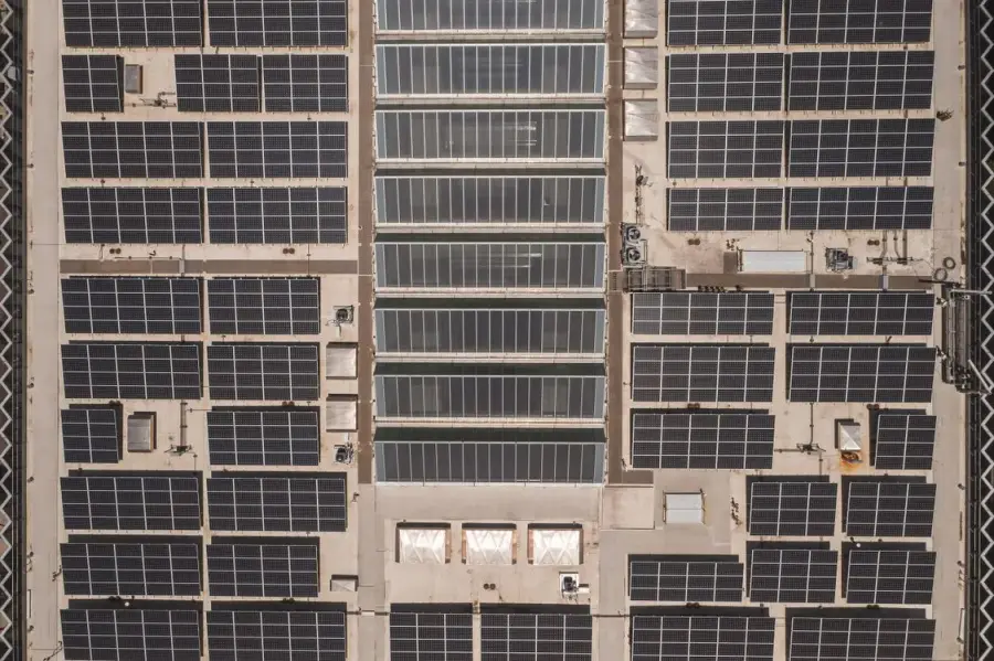 Luchtfoto van een dak volledig bedekt met zonnepanelen in een strak grid-patroon